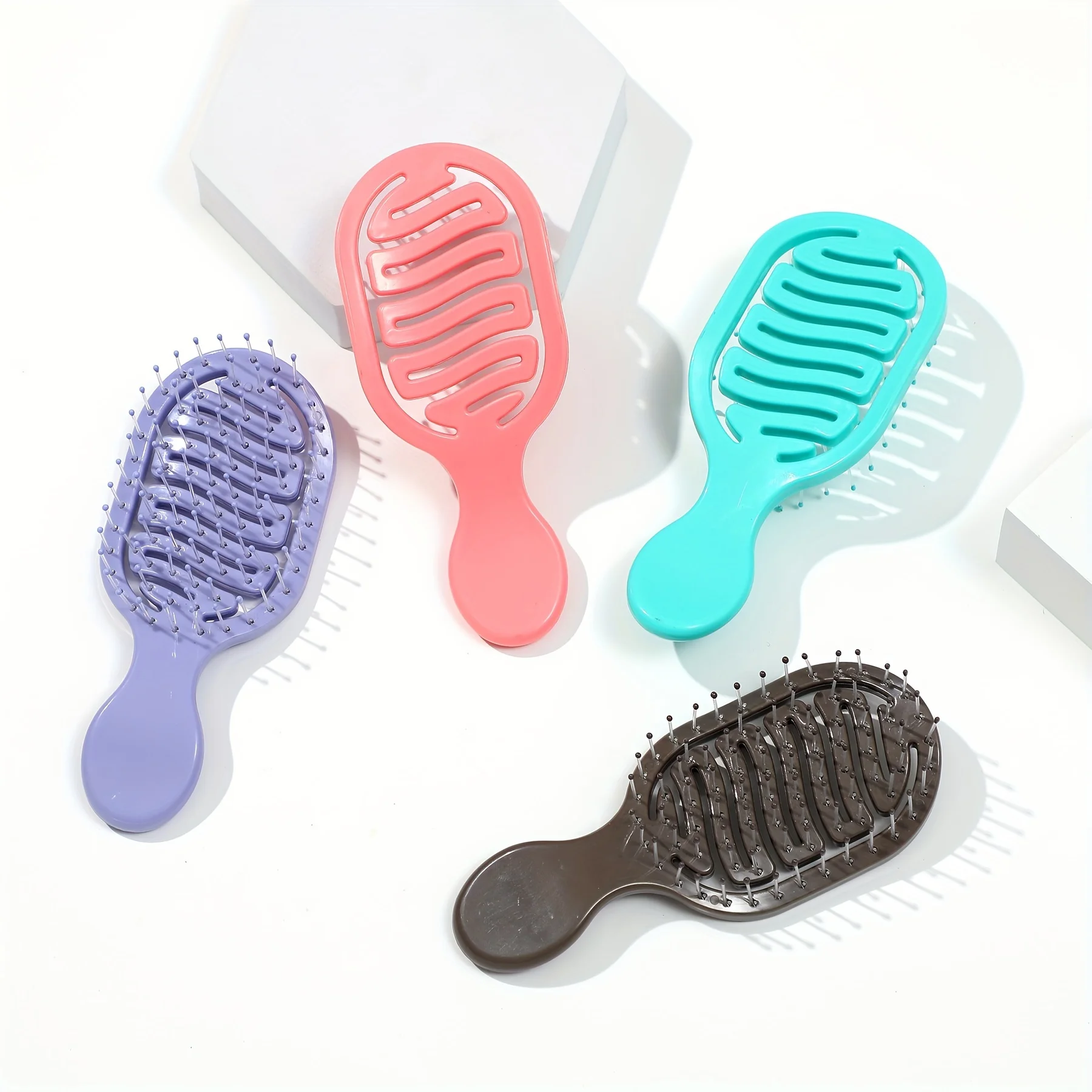 Mini Track Hairbrush, portable hollow design with nylon bristles, ergonomic handle, compact and lightweight—a travel essential.