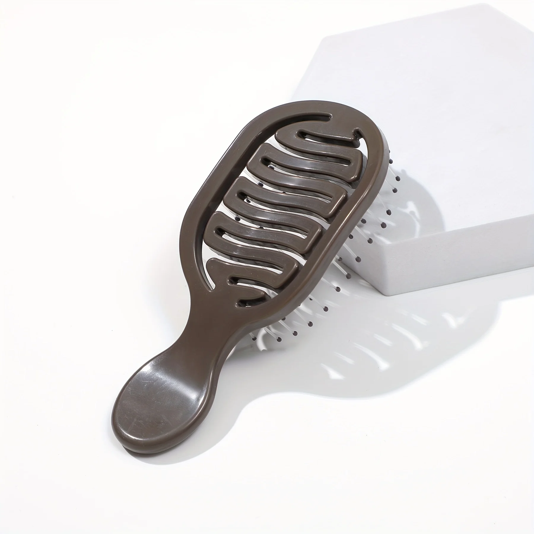 Mini Track Hairbrush, portable hollow design with nylon bristles, ergonomic handle, compact and lightweight—a travel essential.