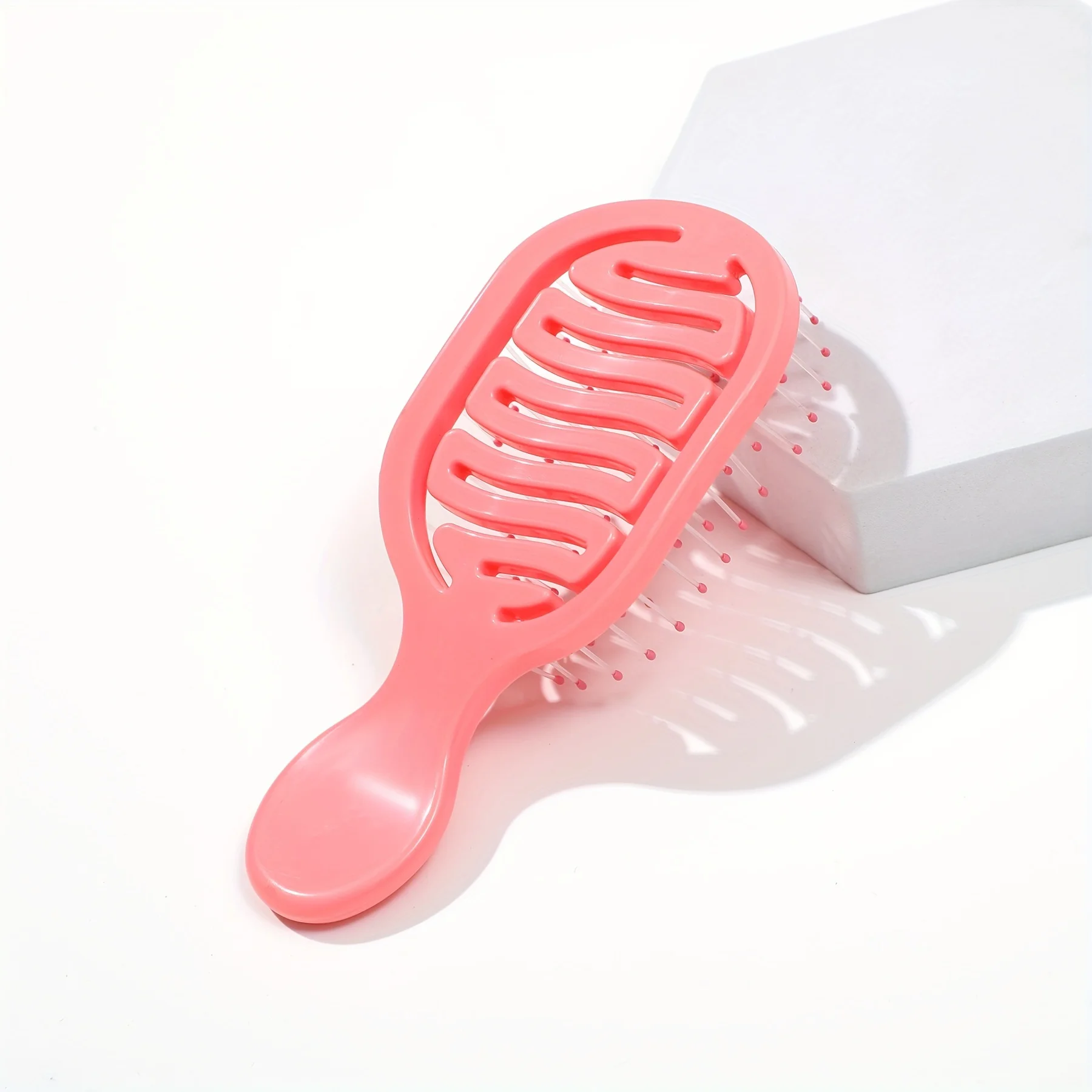 Mini Track Hairbrush, portable hollow design with nylon bristles, ergonomic handle, compact and lightweight—a travel essential.
