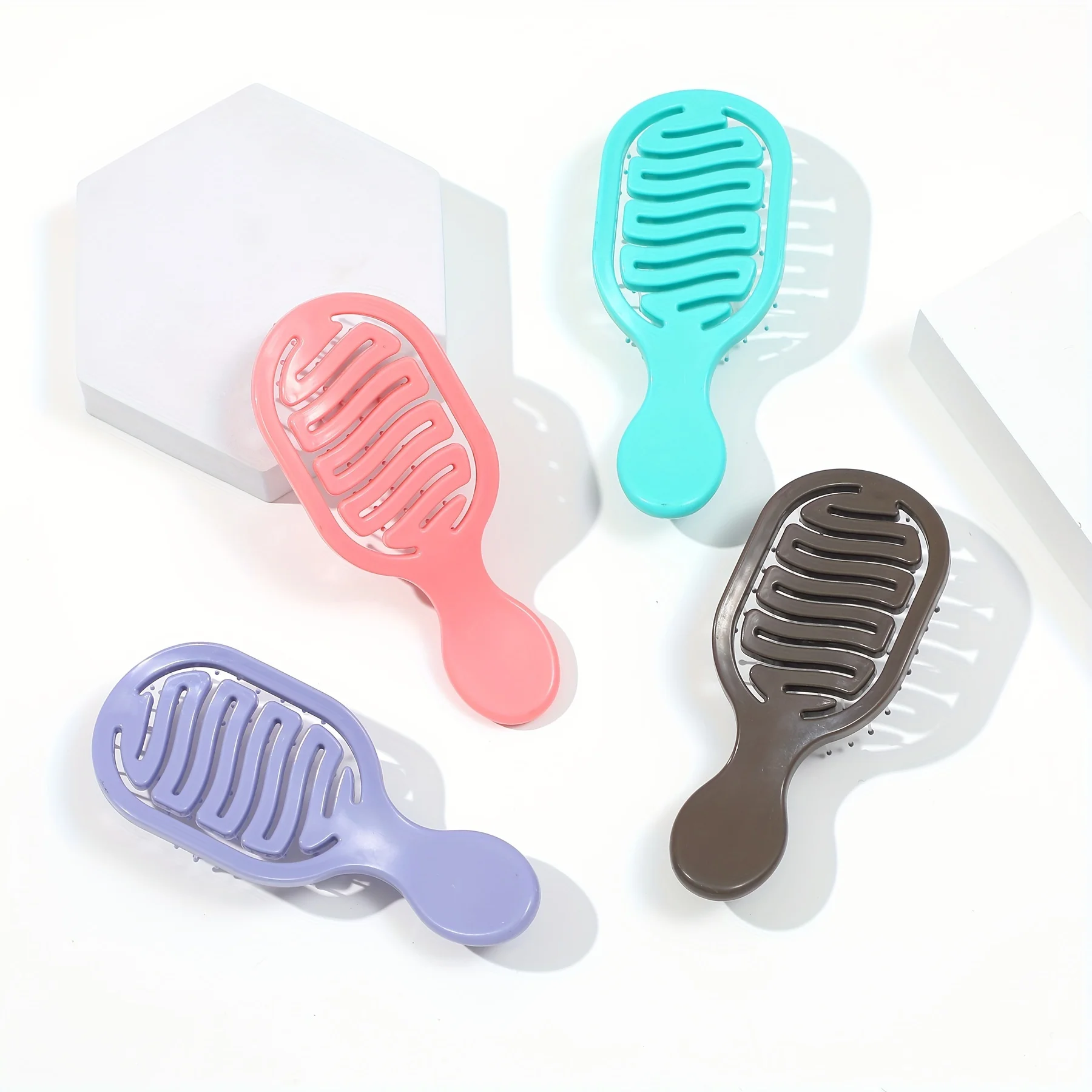 Mini Track Hairbrush, portable hollow design with nylon bristles, ergonomic handle, compact and lightweight—a travel essential.