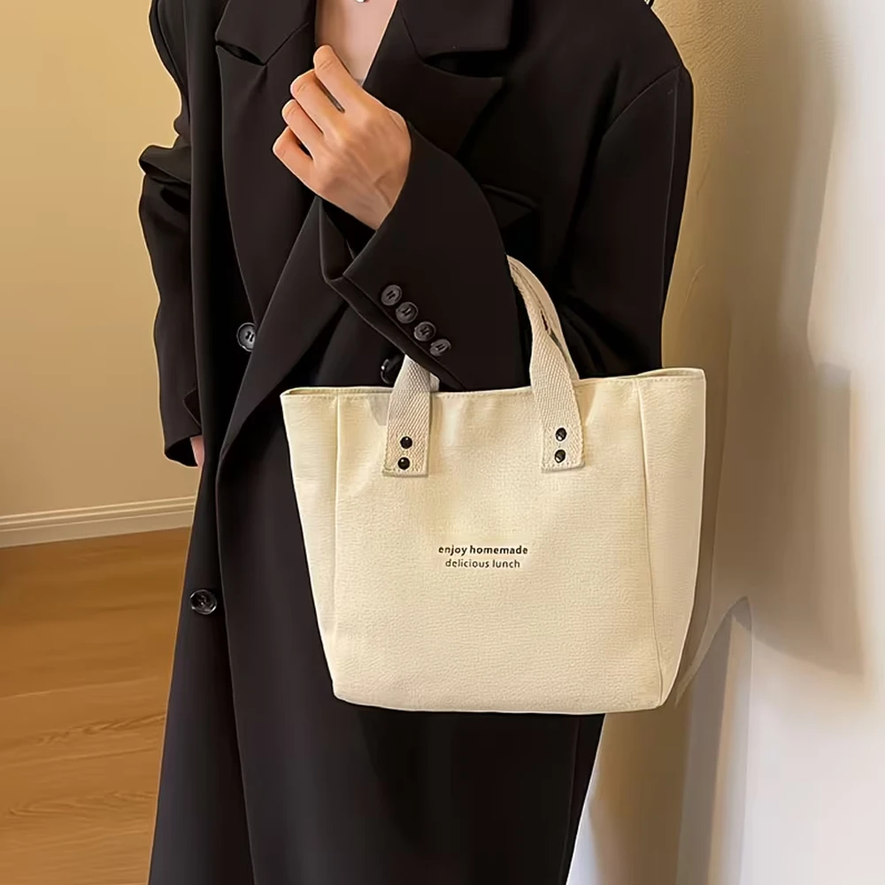 A Casual Canvas Tote Bag with a Bell Pendant and Zipper Closure; This Stylish and Durable Tote Bag Is Perfect for School and Work