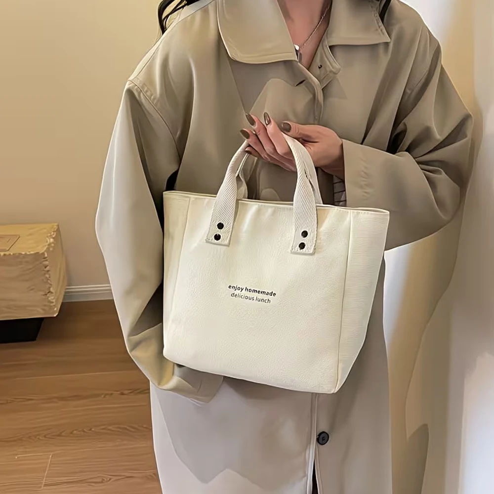 A Casual Canvas Tote Bag with a Bell Pendant and Zipper Closure; This Stylish and Durable Tote Bag Is Perfect for School and Work