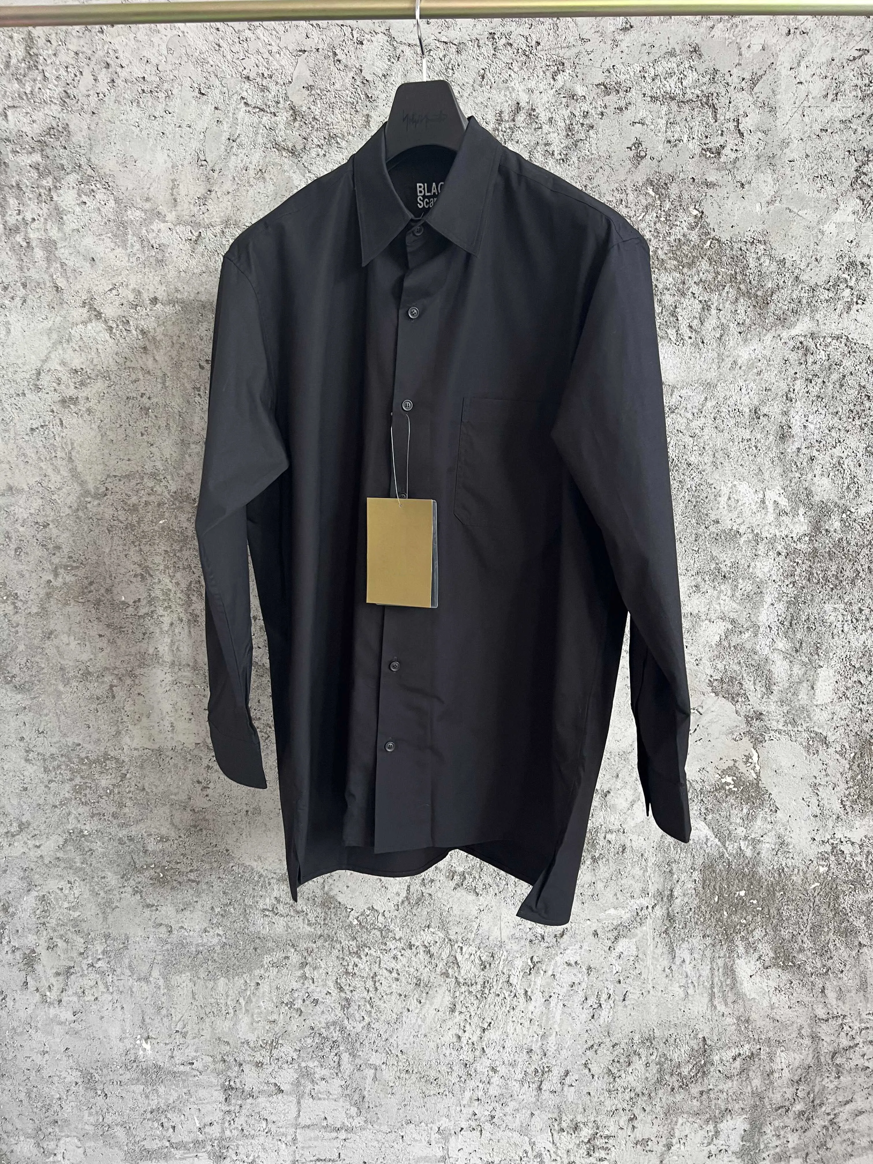 A simple long-sleeved single-breasted shirt with a double-layered collar, solid color and asymmetrical design