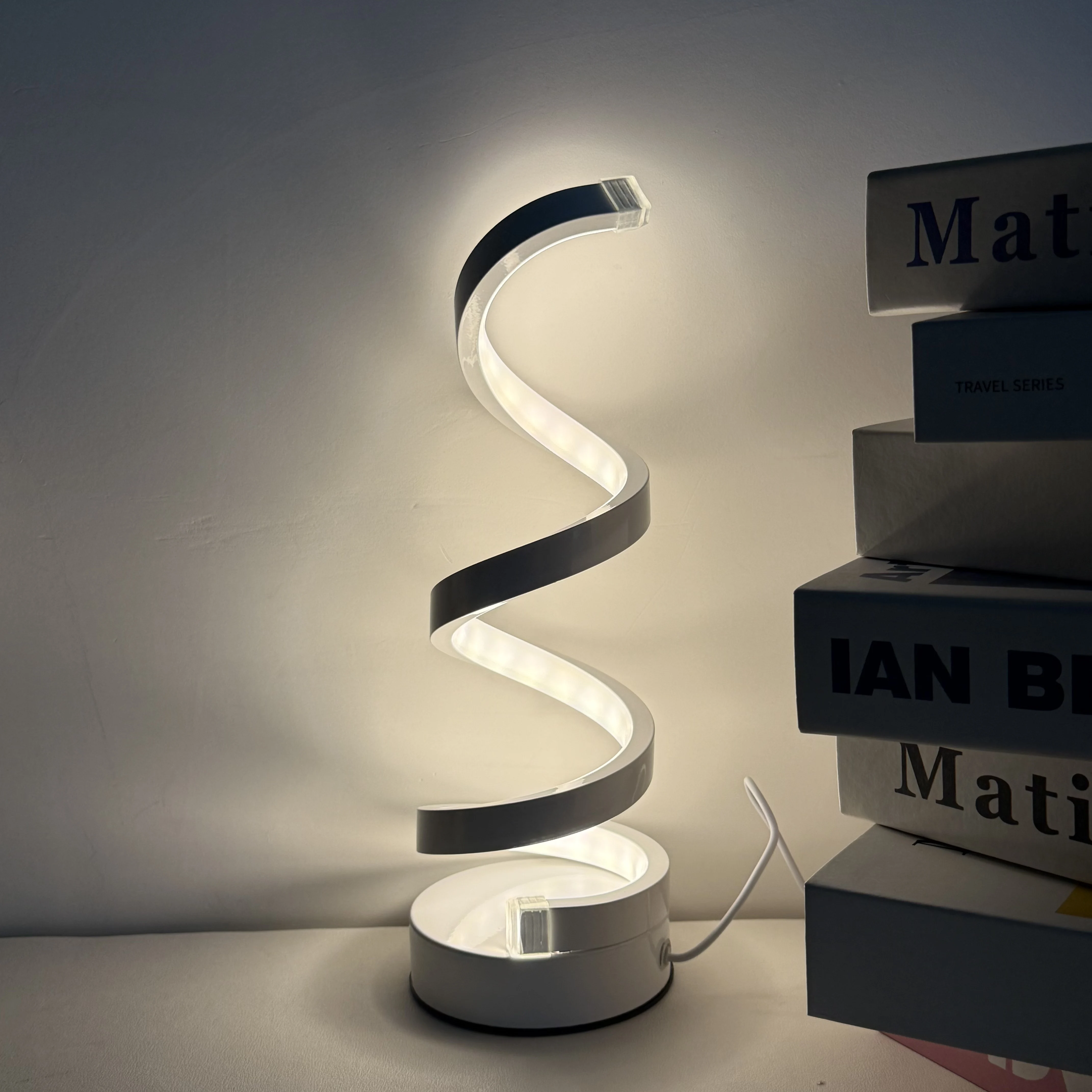 A Modern, Elegant White Spiral Desktop Lamp, Powered by USB with Three-Color Dimming, Suitable for Various Types of Rooms.
