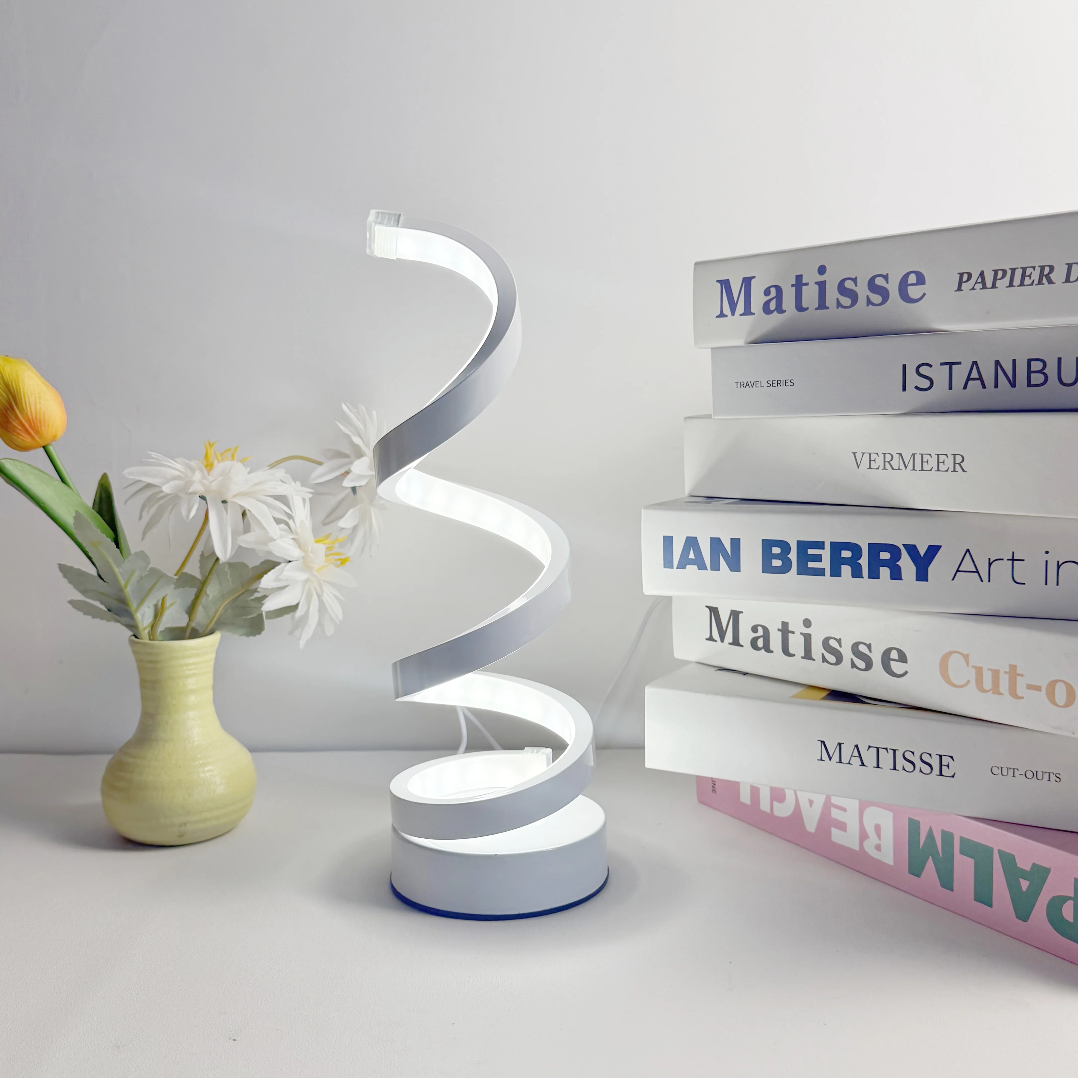 A Modern, Elegant White Spiral Desktop Lamp, Powered by USB with Three-Color Dimming, Suitable for Various Types of Rooms.