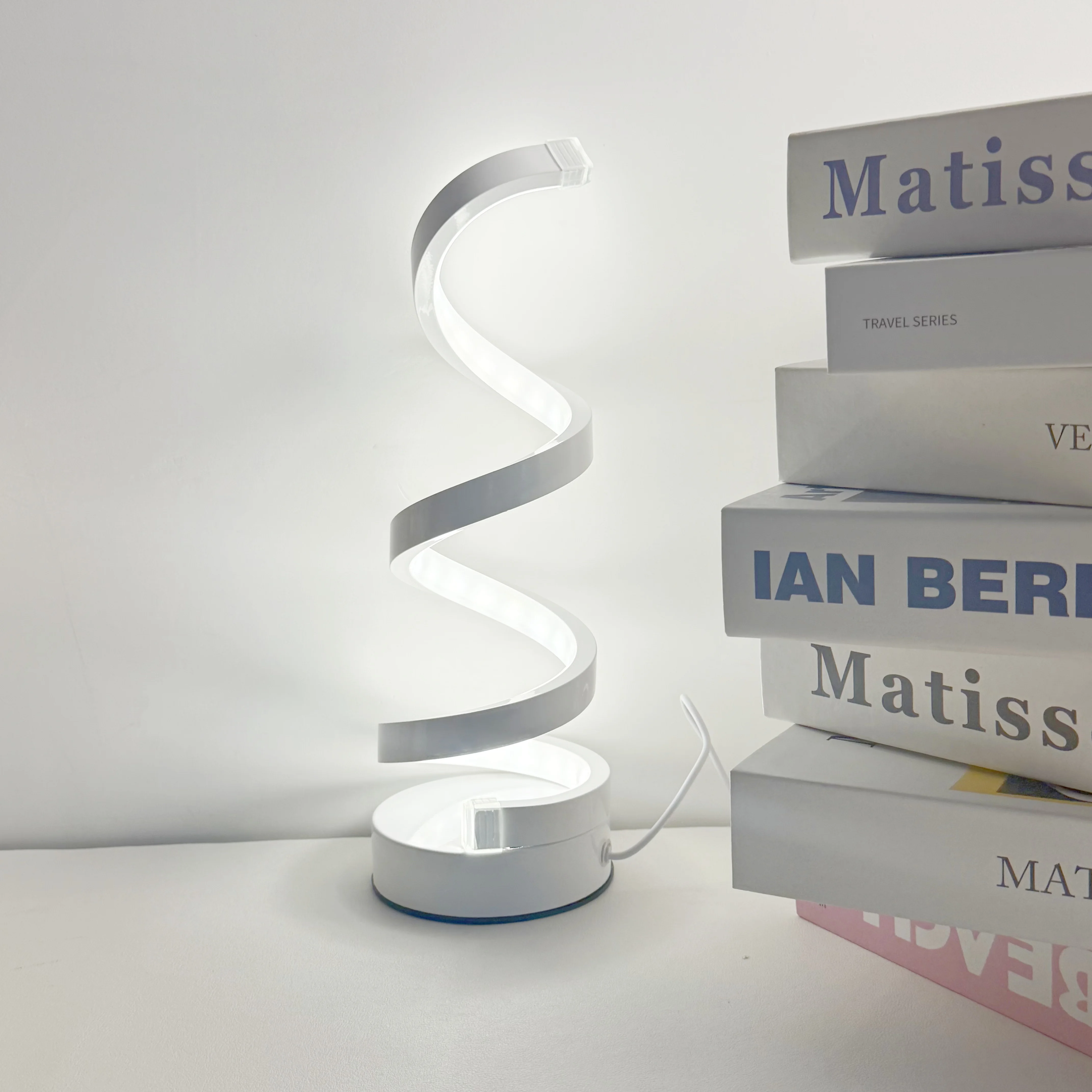 A Modern, Elegant White Spiral Desktop Lamp, Powered by USB with Three-Color Dimming, Suitable for Various Types of Rooms.
