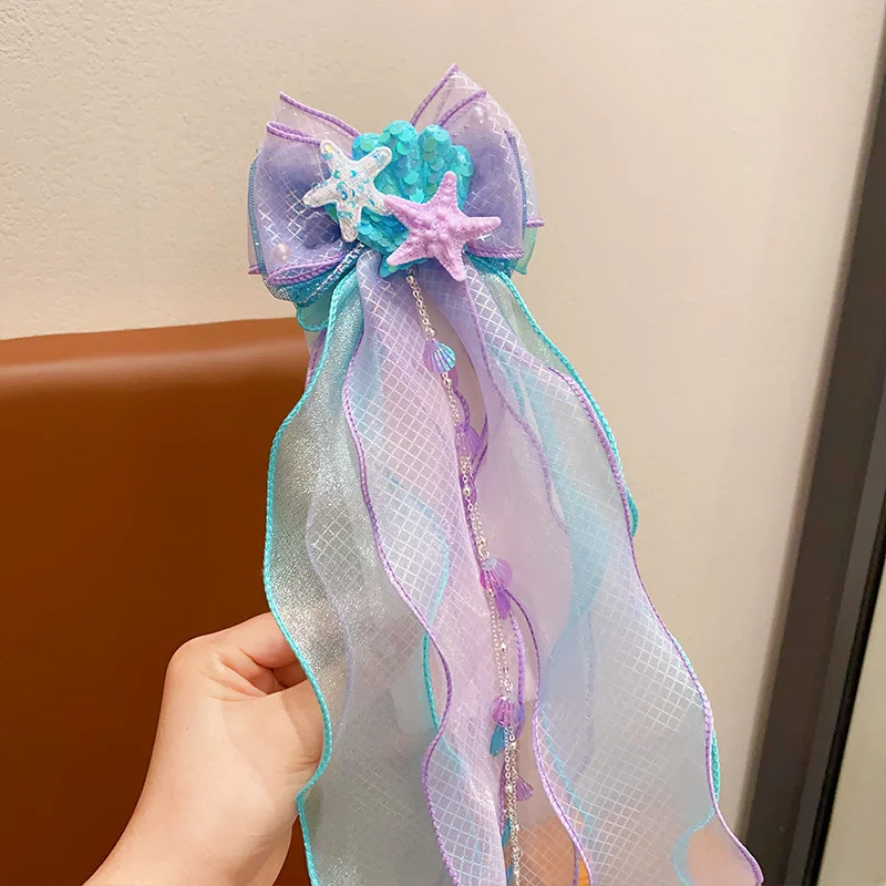 A mermaid princess bow hair clip with a floating gauze pair for a birthday performance hair accessory and veil