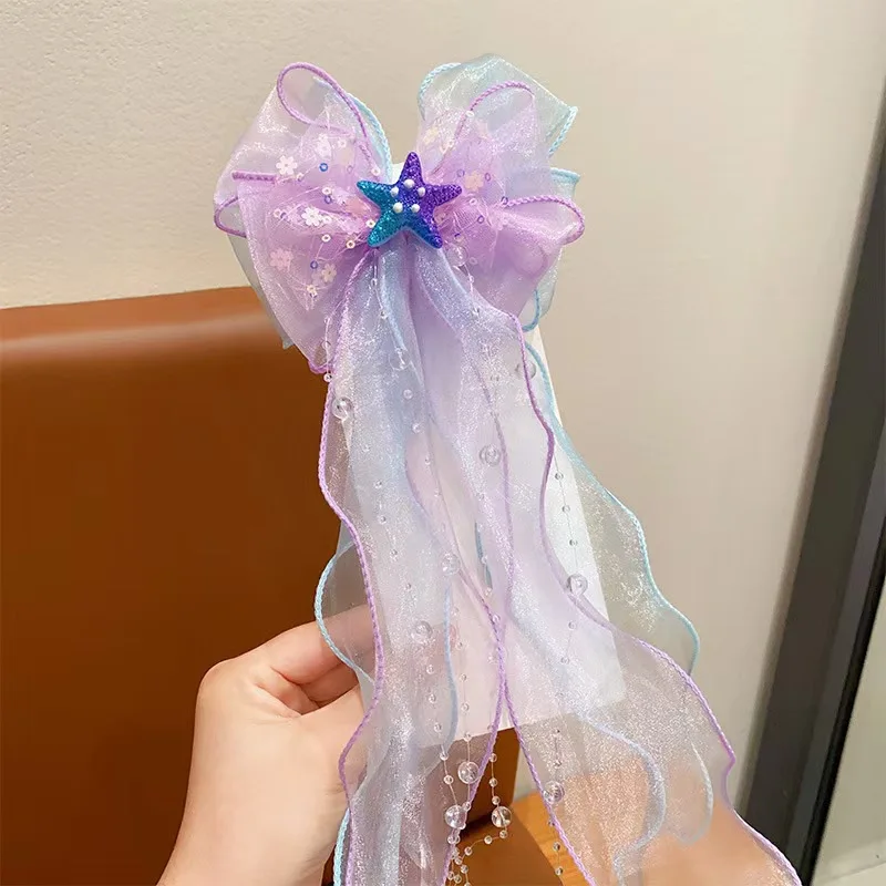 A mermaid princess bow hair clip with a floating gauze pair for a birthday performance hair accessory and veil