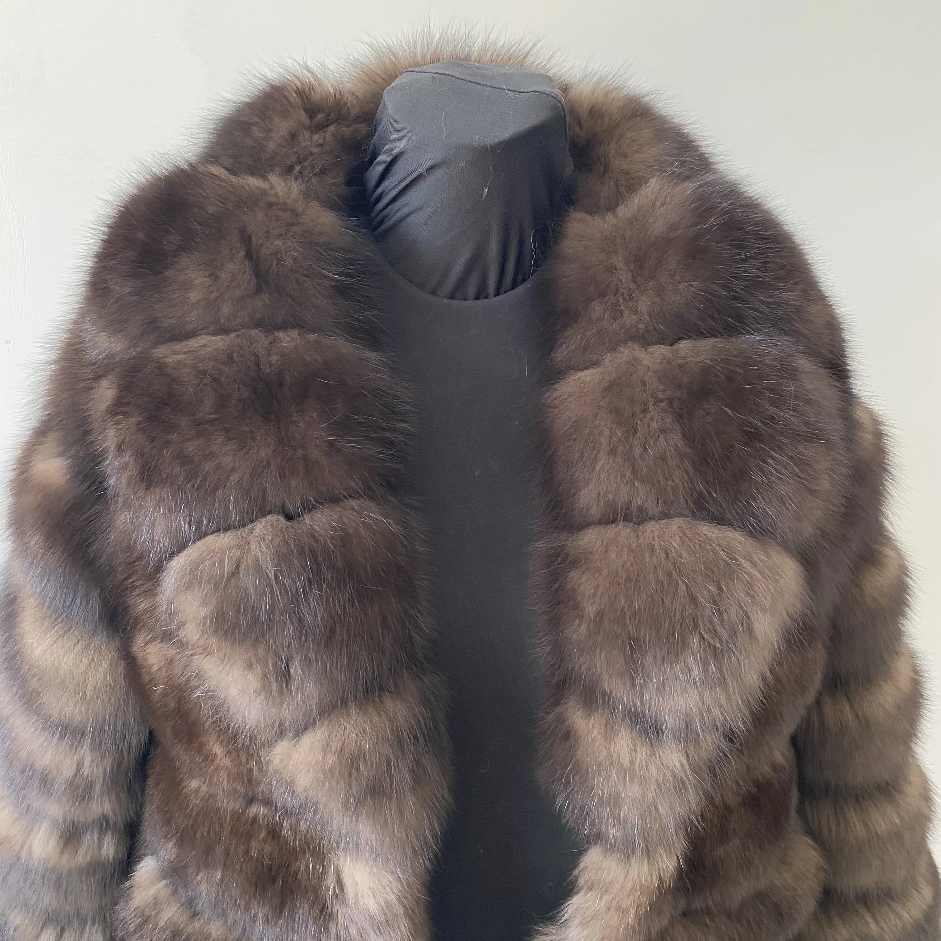Lady's fashionable warm natural fur coat with a collar for warmth, luxurious high street outerwear